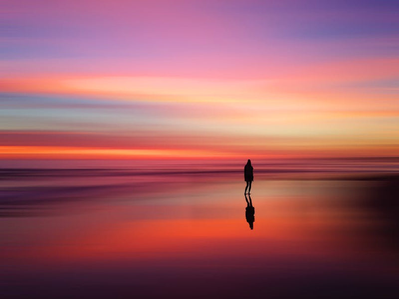 person sitting on sunset beach calm reflection australia