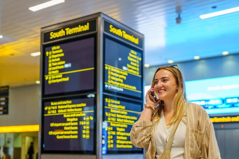 backpacker with luggage at airport departure terminal checking phone