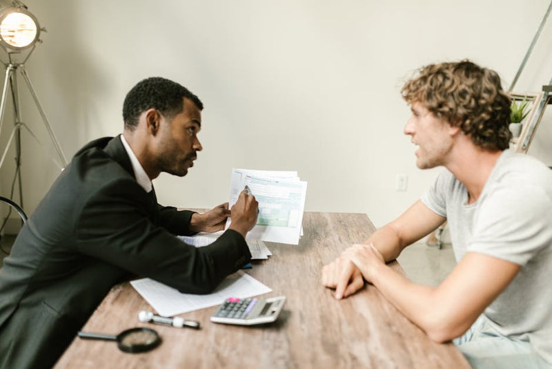 accountant reviewing documents with client at desk in modern office